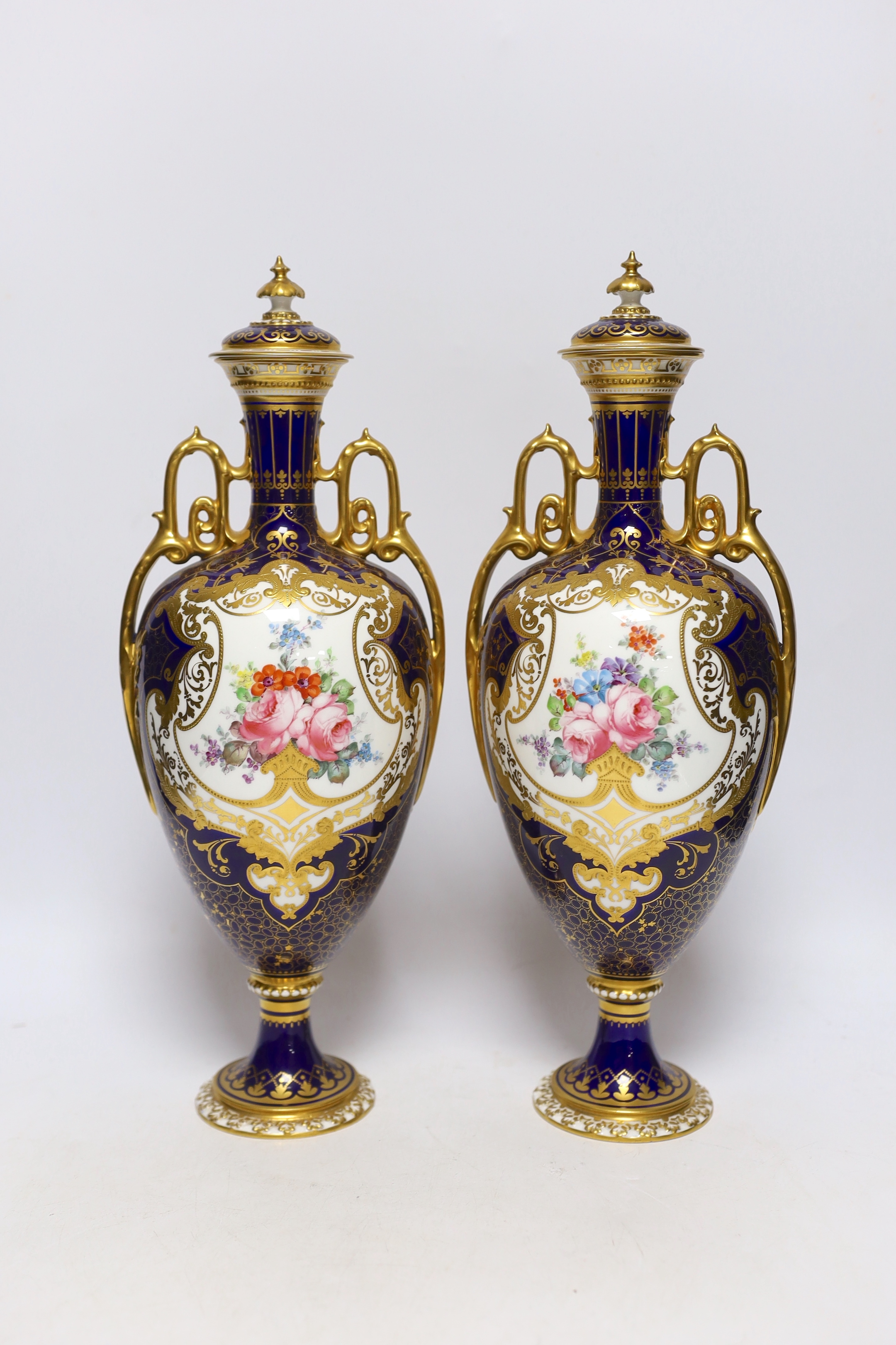 A pair of Royal Crown Derby porcelain urns and covers together with a smaller example and an Imari style jar and cover, 36cm high